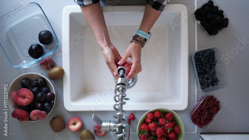 Time Lapse with Girl washing strawberries and other fruits in a sink in kitchen