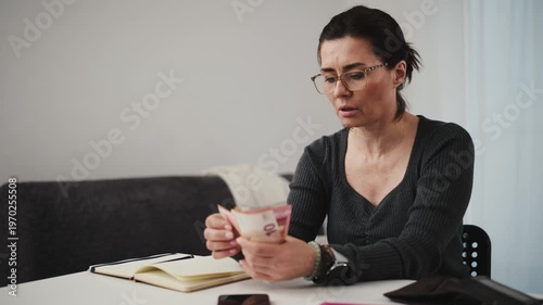 Woman Planning Expenses Counting Money And Taking Notes In A Notebook