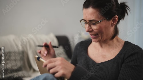 Woman Happily Taking Notes In Diary
