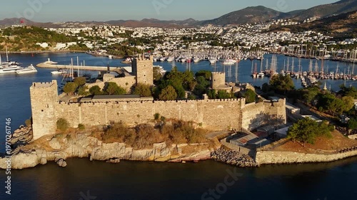Aerial view of Bodrum Castle on the coast with marina and yachts. Historic fortress surrounded by Mediterranean sea and cityscape in Turkey.