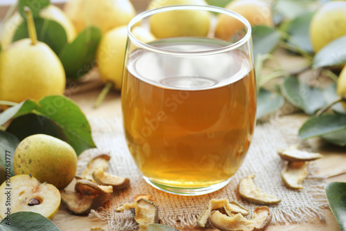 Pear juice, syrup or compote in a glass  with fresh fruits and leaves on rusric wooden table, closeup, natural homemade drinks, healthy eating concept