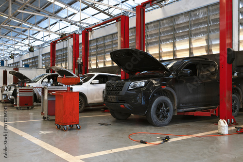 Cars on Hydraulic Lifts Inside Modern Auto Repair Service Garage