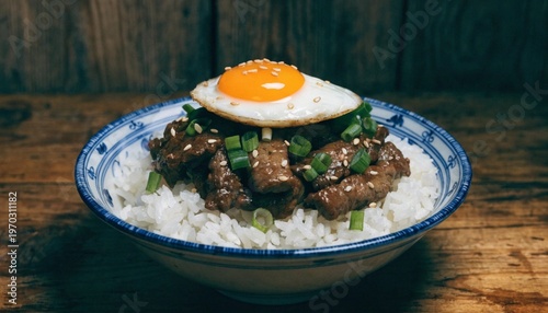 A delicious bowl of rice topped with tender beef, a perfectly cooked egg, and fresh green onions, garnished with sesame seeds
