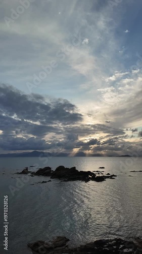 Seaside town of Turgutreis and spectacular sunsets. Bodrum, Turkey. A large rock in the middle of the Aegean Sea. vertical video for social media. 
