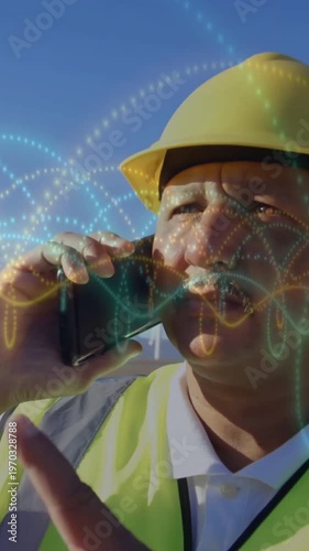 Vertical video: Site pro raising radio to ear after call, checking time while waves overlaying face