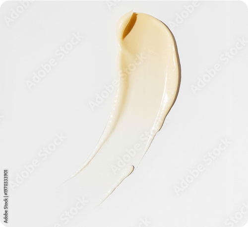 Fotografie Cosmetic foundation texture swiped on a white background with natural light