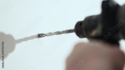 Close up of man drilling hole in wall with electric drill for shelf installation, 10-bit 4K.