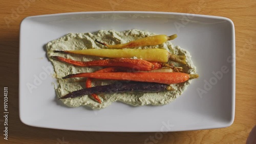 Wallpaper Mural Colorful roasted carrots arranged on a creamy spread using tongs. Torontodigital.ca