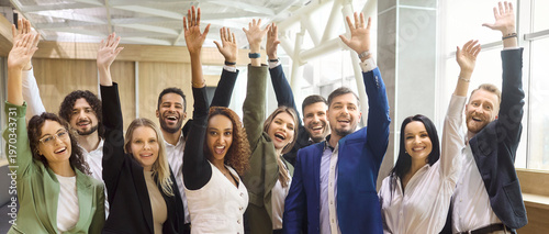 Team business professionals and colleagues cheer celebration success. Diverse coworkers raise hands in a bright office, showing unity and confidence after a win. Success and teamwork unity concept.
