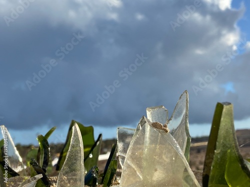 Obraz na płótnie Close-up of broken green clear glass shards embedded in the top of a concrete wall as a traditional security barrier