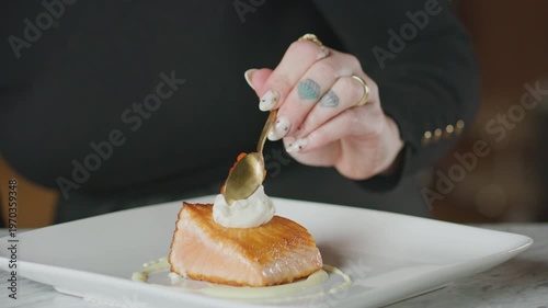 Wallpaper Mural Chef garnishes a plated salmon dish with dill and caviar using tweezers. Torontodigital.ca