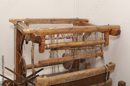 Old wooden weaving loom, close-up. Detailed view antique loom wooden structure with warp and weft threads textile craft tool