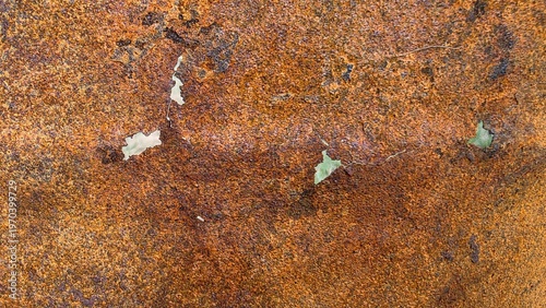 Close-up of heavily rusted metal sheet with holes and cracks showing aged brown and orange textures. Concept of degradation and destruction