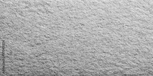 Textured grey stone surface showcasing the raw beauty and natural pattern of the material, evoking a sense of enduring strength and timeless elegance. 