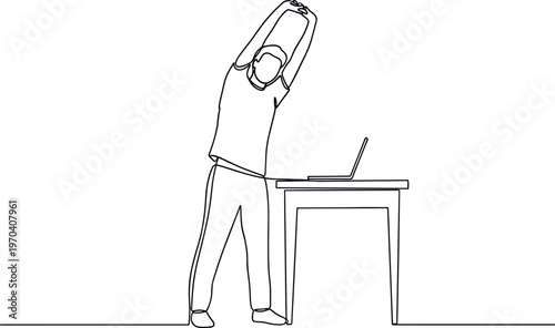 A man stretching at his desk while working on a laptop