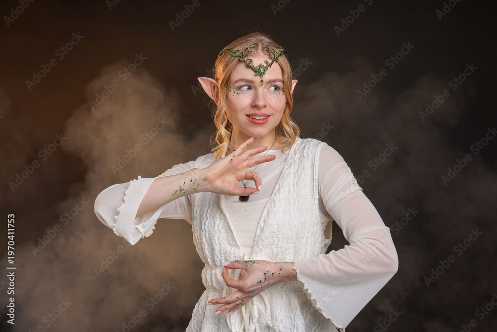 Obraz premium Beautiful girl dressed as elf on black background with smoke