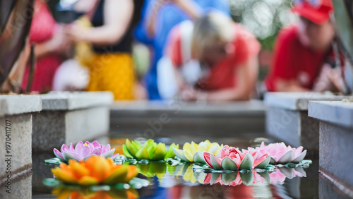 Tableau sur toile Colorful lotus flowers floating on water surface with blurred people in Vietnam