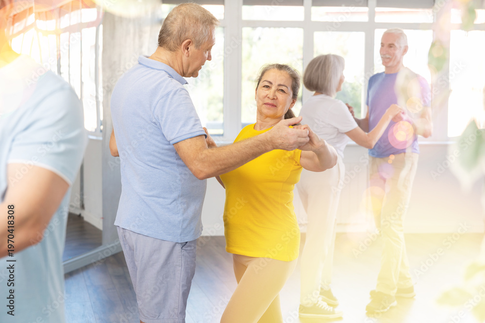 Fototapeta premium Elderly man and elderly woman dance ballroom dance waltz in studio