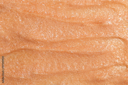 Close-up macro texture of shimmering beige cosmetic scrub with fine particles