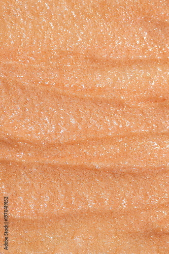 Close-up macro texture of shimmering beige cosmetic scrub with fine particles