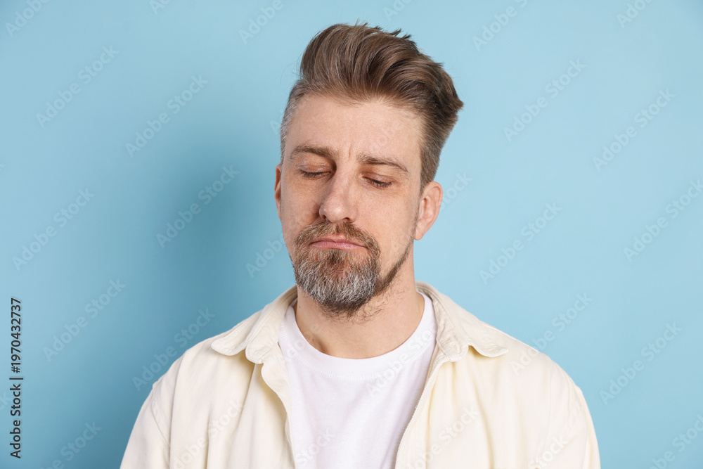 Fototapeta premium Resentment. Frustrated man on light blue background