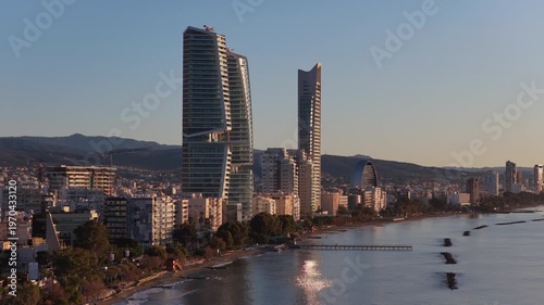 Aerial drone view of Limassol coastline with city buildings and beach in the background