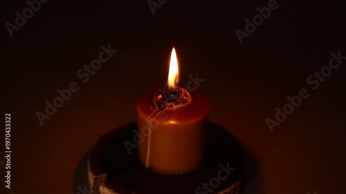 Closeup candle beautiful burning on dark shadow red warm background, candle fire flame light with empty copy space. Magic ritual with romantic candle wax fire