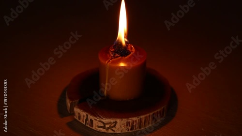 Closeup candle beautiful burning on dark shadow red warm background, candle fire flame light with empty copy space. Magic ritual with romantic candle wax fire
