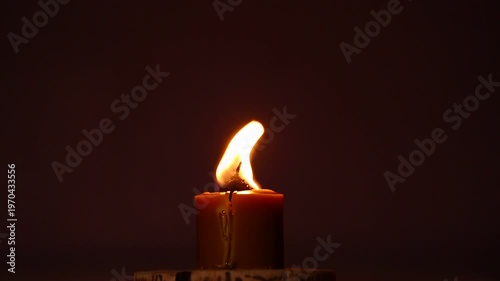 Closeup candle beautiful burning on dark shadow red warm background, candle fire flame light with empty space. Magic ritual with romantic candle wax fire