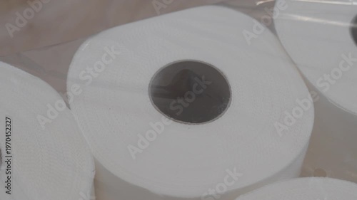 Single toilet paper roll in close-up with soft shadows and neutral background. Minimal product-style shot highlighting shape and texture.