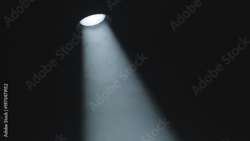 Spotlight beam creating a powerful theatrical illumination on a dark background