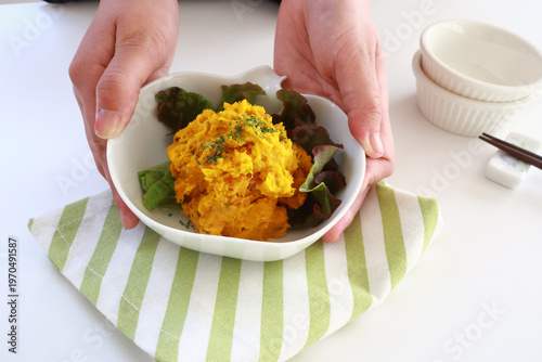 かぼちゃのサラダを差し出す手