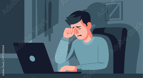 A man sits at a desk rubbing his eyes in frustration while working on a laptop in a dimly lit room late at night.