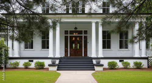 Elegant white colonial mansion with grand entrance and lush green lawn in spring daylight