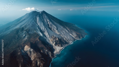 Aerial view of majestic volcanic mountain island surrounded by deep blue ocean