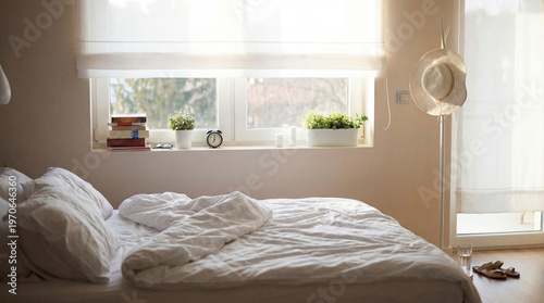 Photos Photograph of a bright and spacious bedroom with an unmade bed, window, plants, and natural morning light