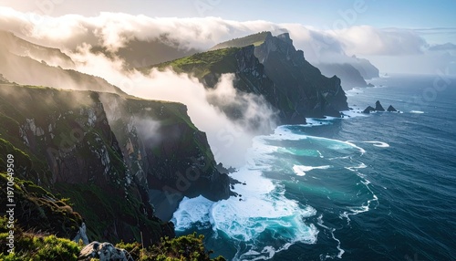 Dramatic coastal cliffs emerge from the ocean, shrouded in mist under a cloudy sky