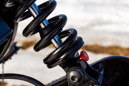 Canvas-taulu Close-up of a sleek black e-bike rear spring shock absorber with a vibrant red a