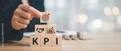Businessperson placing a target block on top of blocks labeled kpi