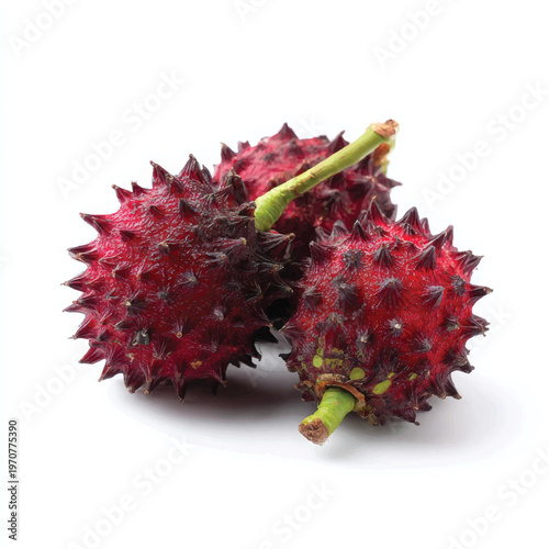 A close-up view of three red rambutan fruits on a white background