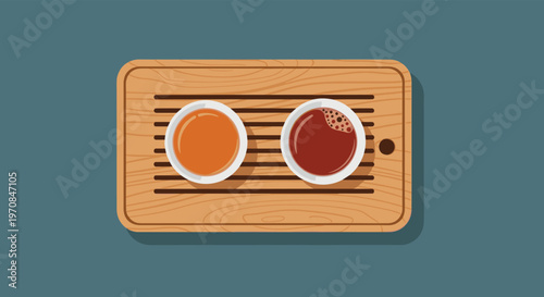 Overhead view of two cups of different tea varieties one orange and one dark brown resting on a light wooden serving tray.