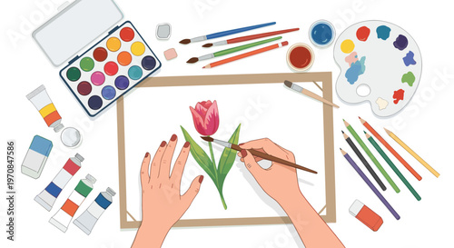 Top down view of an artist painting a pink tulip flower using watercolor paints and various brushes on a desk.