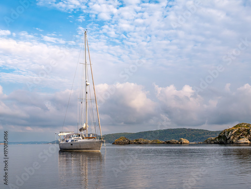 Anchored sailboat in calm water of Hakefjorden near Lilla Dyrön in Bohuslän, west coast Sweden