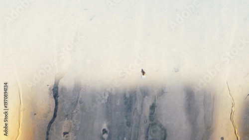 Dirty and dusty dark window glass in the sunset. Abstract dirty window glass background. Window with very dirty and dusty glass in daylight in the sunset. Condensation on the fogged windows glass.