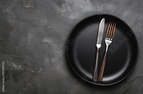 Elegant Minimalist Table Setting with Black Plate and Silver Cutlery