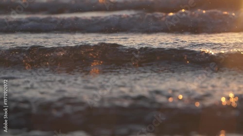Red sunrise sea waves close up, shallow dof