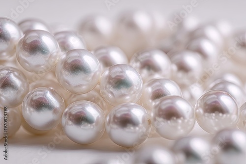 Close-up of a lustrous, creamy-white string of pearls, elegantly draped, showing individual orbs