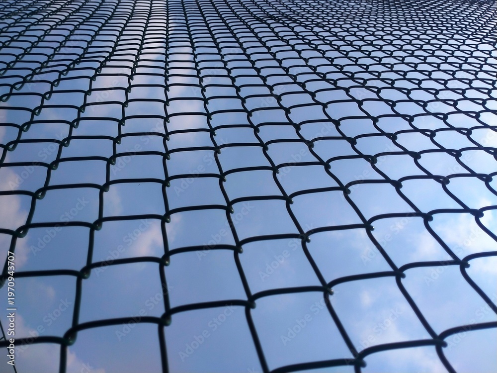 Obraz premium Geometric Chain Link Fence with Blue Sky Background Perspective