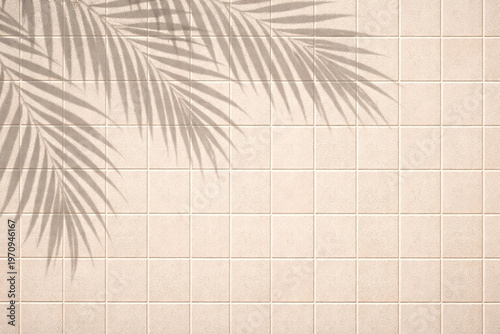 Delicate palm leaf shadow on beige mosaic tile with scan like focus