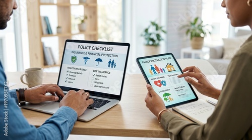 A diverse couple reviews an insurance policy checklist and family protection plans on a laptop and tablet at home to ensure long term financial security and health coverage for their future.